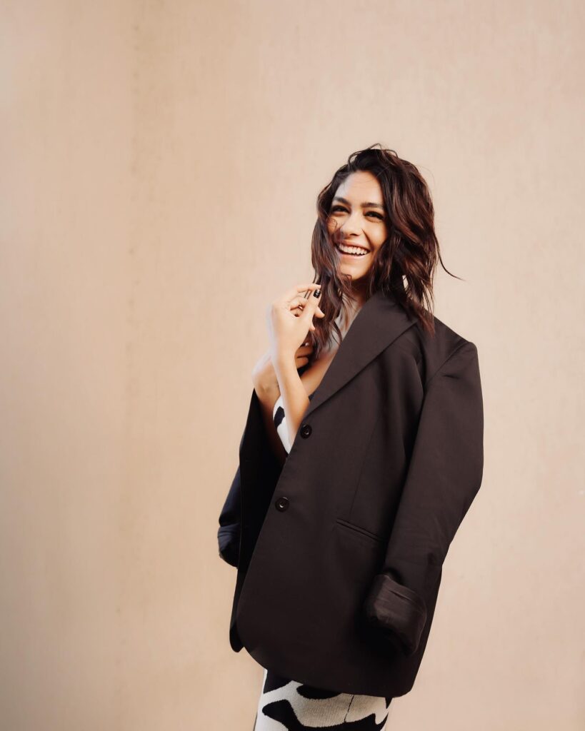 A woman in a black blazer posing for a photo.