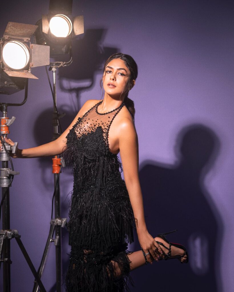 A woman in a black dress posing for a camera.